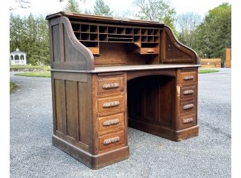 An Antique Paneled Oak Roll Top Desk