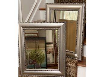 A Pair Of Beveled Mirrors In A Silver-Toned Frame