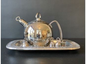 A Shiny Chrome Teapot On A Wilton Armetale Tray