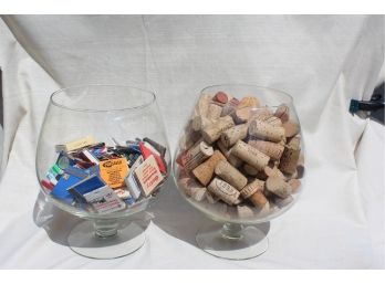 2 Large Glass Brandy Snifters One Filled With Matchbooks & The Other Filled With Wine Corks