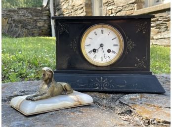 An Antique Bronze Sphinx And Onyx Paperweight And A Mantle Clock