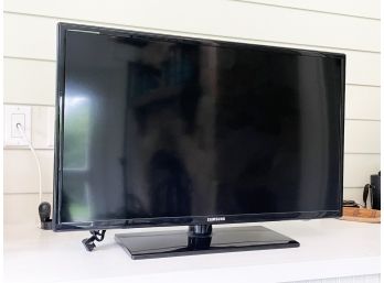 A Samsing 32' Flat Screen TV On Stand