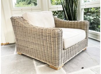 A Modern Wicker Arm Chair With Linen Cushions And Outdoor Covers By Restoration Hardware