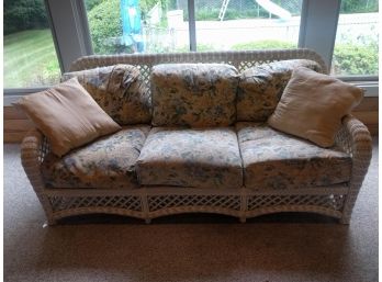 White Wicker Sofa With Floral Patterned Cushions