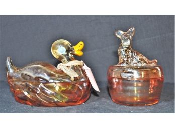 Two Beautiful Pieces Of Amber Color Carnival Glass Covered Dishes Duck & A Scottie Terrier