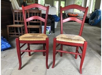 A Pair Of Red Painted Wood Chairs With Rush Seats