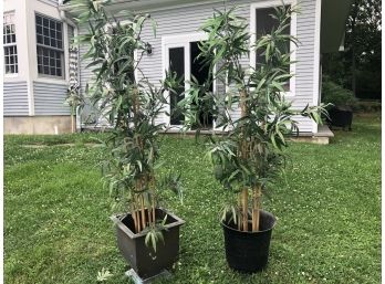 A Pair Of Potted Faux Bamboo Plants In Metal Containers