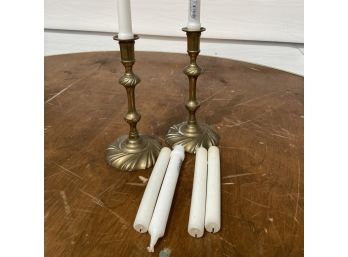 A Pair Of Brass Candlesticks And Candles