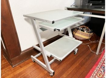 A Modern Glass And Chrome Office Desk With Keyboard Shelf