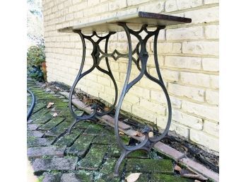 An Antique Cast Iron Sewing Machine Base With Rustic Wood Top