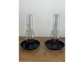 A Pair Of Candle Holders With Glass Hurricanes