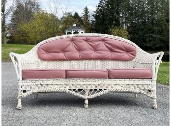 A Solid Vintage Wicker Sofa With Vinyl Cushions