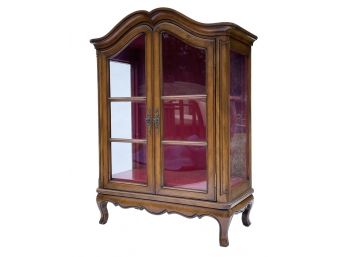 A Vintage Curio Cabinet With Paneled Glass Doors