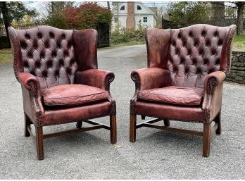 A Pair Of Oxblood Leather Wingback Chairs With Nailhead Trim