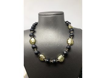 A Glass Bead Necklace With Black Beads And Silver Tone Detailing