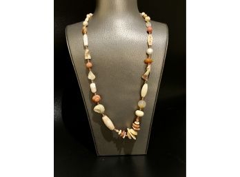 A Beaded Necklace Made From Seashells And Coral