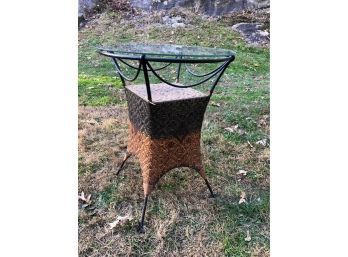 A Small Round Glass And Rattan Table