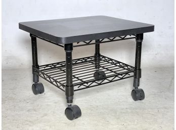 A Rolling Metal Cart With Formica Top