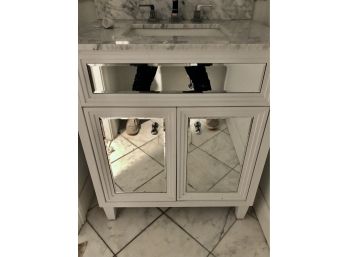 A Small Mirrored Vanity With Granite Top And Under Mount Sink