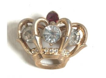 A Pin In The Shape Of A Crown With Huge Rhinestones
