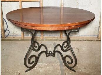 An Extendable Hard Wood Dining Table With Wrought Iron Base