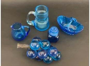 A Collection Of Vintage Display Items In Blue Glass