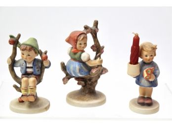 Three Hummel Figurines 'Apple Tree Boy', 'Apple Tree Girl' And 'Advent Candlestick With Nosegay'