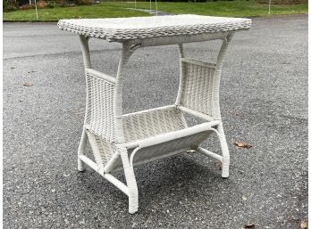 An Antique Wicker Side Table With Book Shelf Below