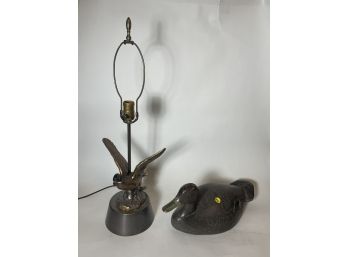 AN ANTIQUE DUCK DECOY WITH A BRONZE DUCK LAMP