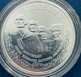 COMMEMORATIVE 90 PERCENT SILVER DOLLAR COIN - 1991 MOUNT RUSHMORE NATIONAL MEMORIAL - IN PLASTIC CAPSULE