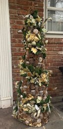 Artificial Christmas Tree Decorated In Ribbons And Pinecones