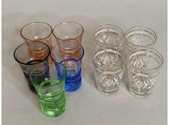 Five Colored Glass Shot Glasses With Four Gold And White Shot Glasses