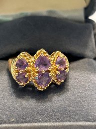 Gold Colored Purple Stone Ring With F Inside A Diamond Maker's Mark