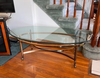 (LR) POST MODERN OVAL GLASS TOP COFFEE TABLE WITH BRASS BASE - 50' BY 28' BY 16'H