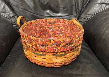 (M-6) LONGABERGER 1995 BASKET WITH LEATHER HANDLES, AUTUMN LEAVES CLOTH & PLASTIC INSERT- 9' BY 9.5'