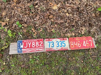 Lot Of Three Vintage License Plates On Wood