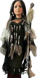 American Indian Themed Stand Up Doll With Square Base With Staff, Feathers, And Beads  (26in Tall)