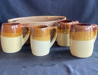 Basket With 4 Brown And Tan Pottery Coffee Mugs.