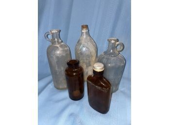 Assortment Of Glass Jugs/ Bottles. Clear And Yellow Amber Glass (5)