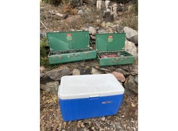 Coleman 2 And 3 Burner Camping Stove Tops And A Large Blue Coleman Cooler.