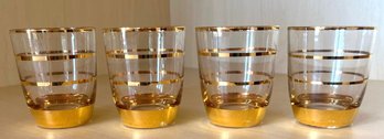 Four Clear Drinking Glasses With Gold Bands