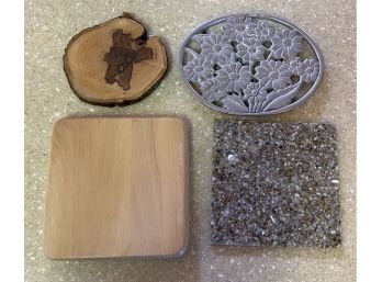 A Handy Grouping Of Trivets Including Wood, Metal And Stone