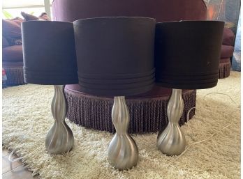 A Grouping Of Three Tall Brushed Chrome Accent Lamps