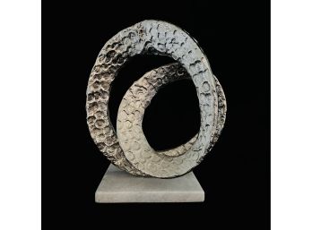 Metal Loop Sculpture On White Marble Base