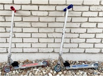Two Razor Push Scooters With Red And Blue Handles