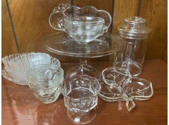 A Grouping Of Glassware Serving Pieces Including Cake Stand And Lidded Jar