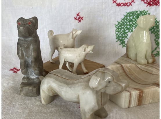 A Grouping Of Dog Themed Carvings Made Of Stone And Bone