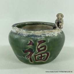 Vintage Green Pot With A Little Mud Man On The Rim Google Translates As 'Blessing'
