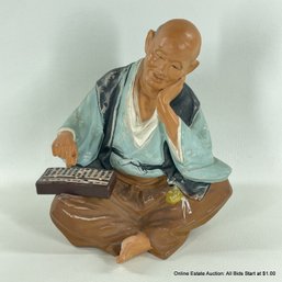 Japanese Ceramic Seated Man With Abacus Statue