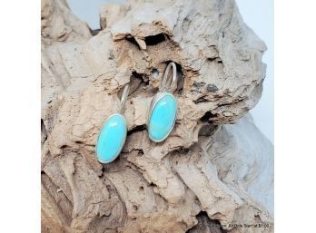 Pair Of Sterling Silver French Hook Back Earrings Each Having A Bezel Set Polished Turquoise Cabochon